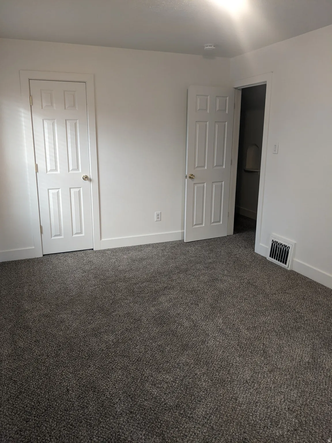 Spacious interior featuring neutral carpeting and crisp white walls