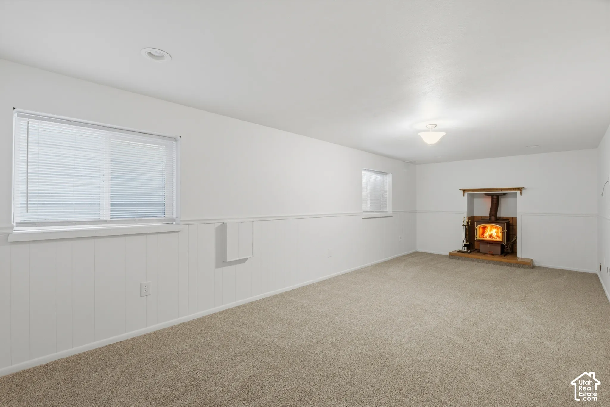 Spacious room with plush carpet flooring and white wainscoting