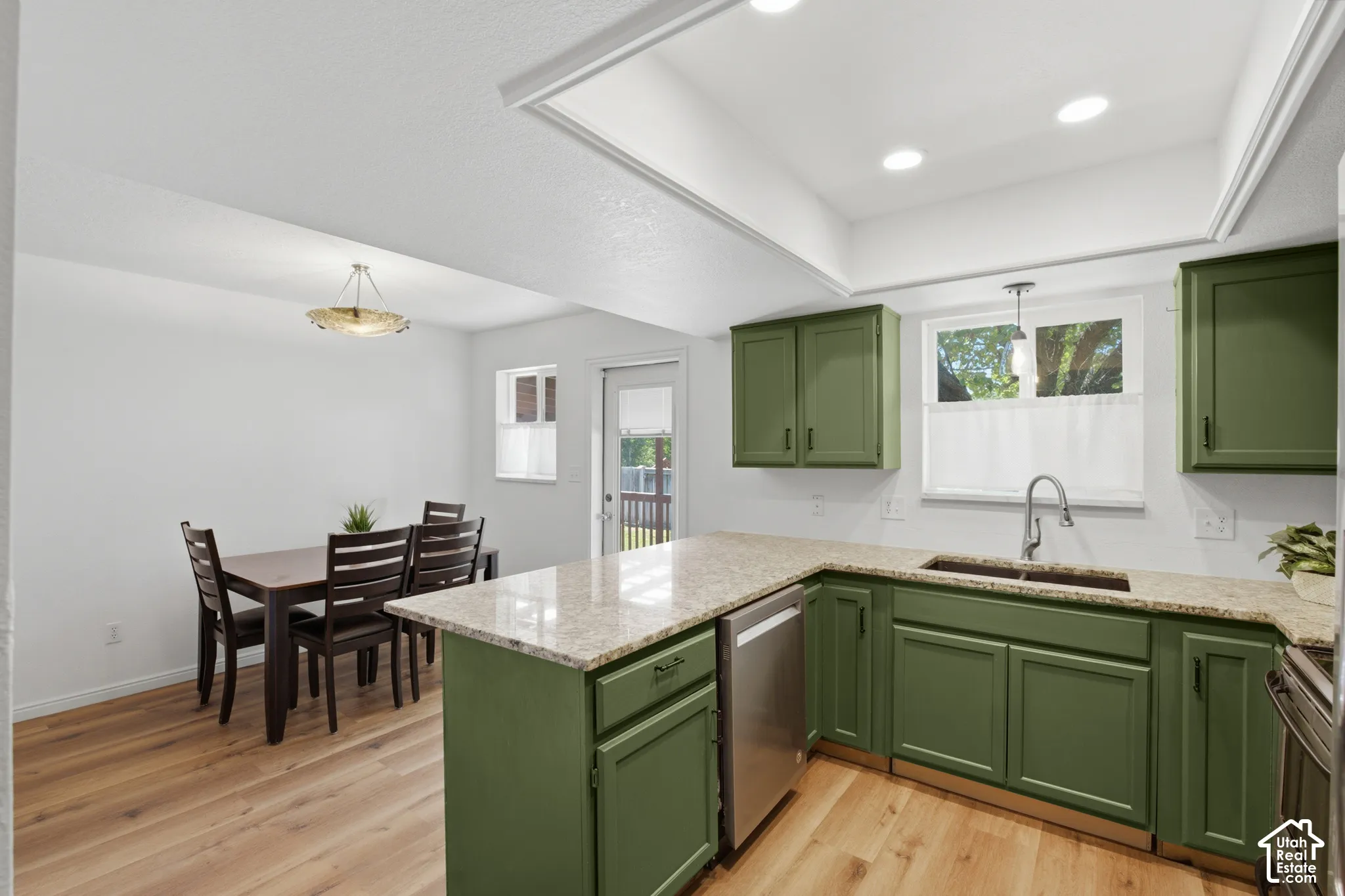 Kitchen featuring green cabinetry, light-toned countertops, and stainless steel appliances