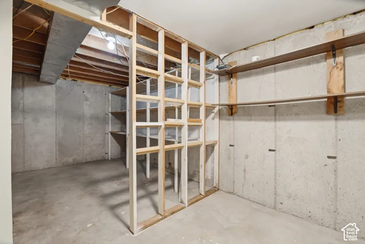 Unfinished basement with concrete slab flooring and exposed concrete walls