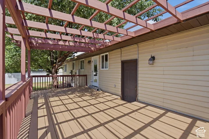 Expansive deck featuring a pergola structure and wood-finish flooring