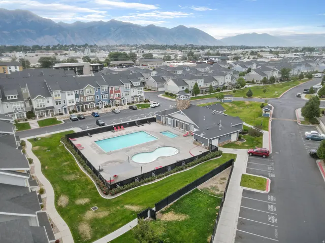 Community pool area featuring two distinct pool shapes, a surrounding patio, and a fenced perimeter