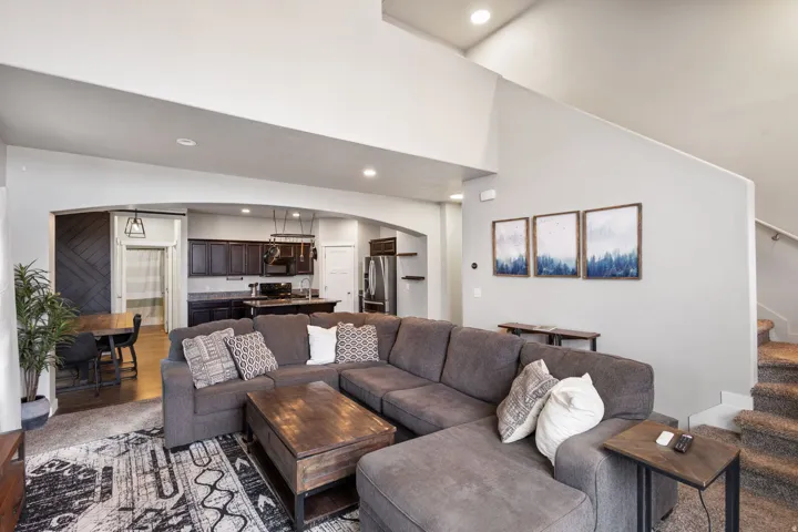 Living area featuring high ceilings, recessed lighting, and carpeted flooring