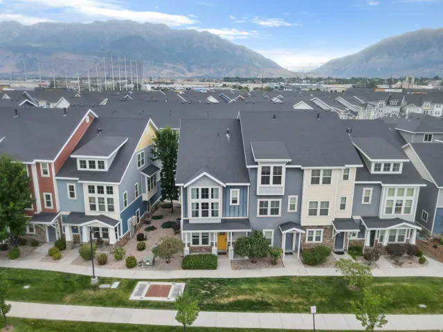 Townhome exteriors featuring varied siding colors, multiple windows, and dark-pitched roofs