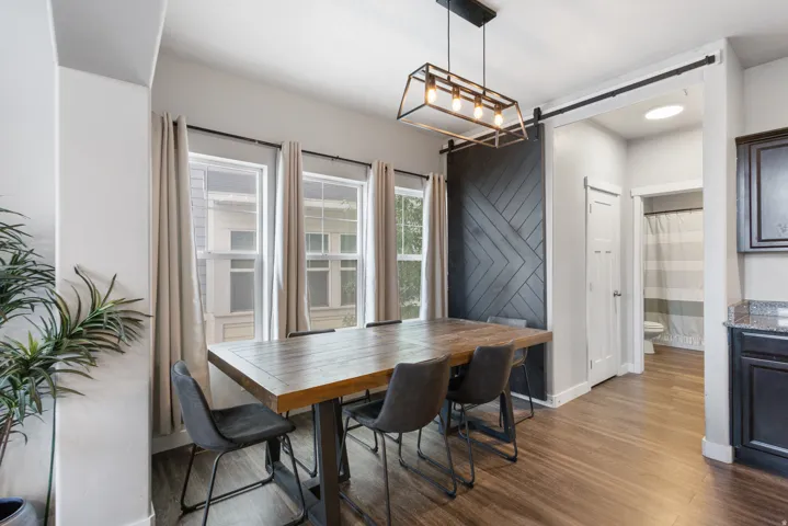 Dining area featuring wood-finish flooring and a linear chandelier
