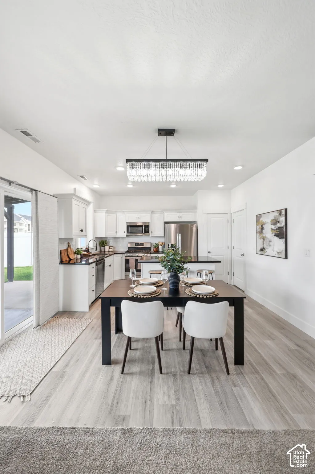 Integrated kitchen and dining area featuring wood-finish flooring