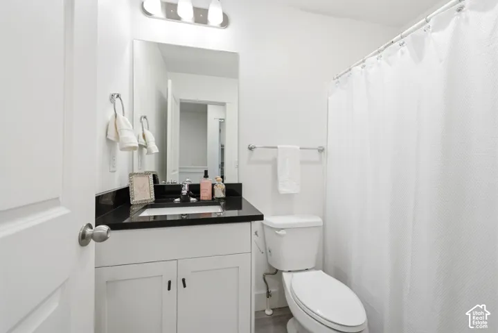 Bathroom featuring a white vanity with black countertop, undermount sink, and chrome fixtures