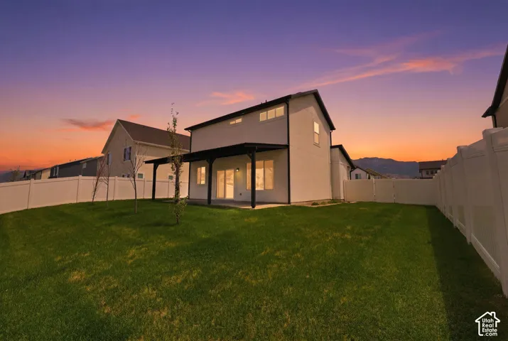 Expansive green lawn with a white vinyl fence enclosing the backyard