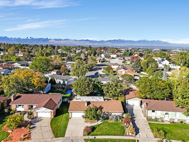 Expansive suburban neighborhood with mature trees and mountain scenery