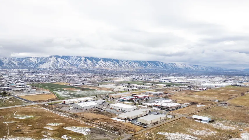 Expansive aerial perspective showcasing a broad landscape with snow-capped mountains in the background