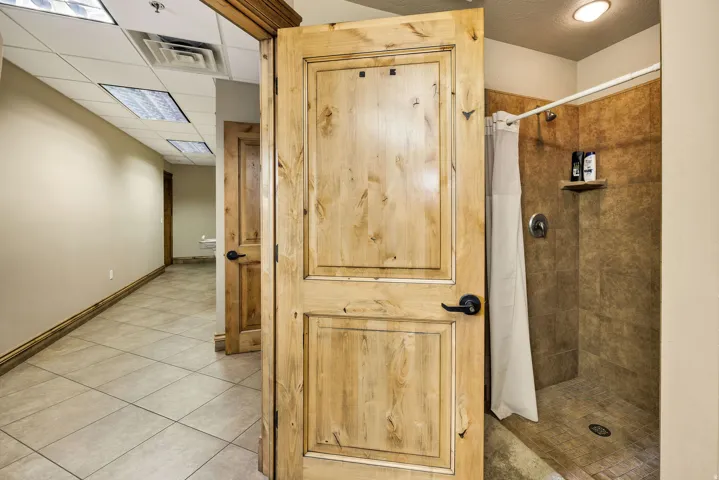 Functional shower stall with brown tile surround and an integrated shelf