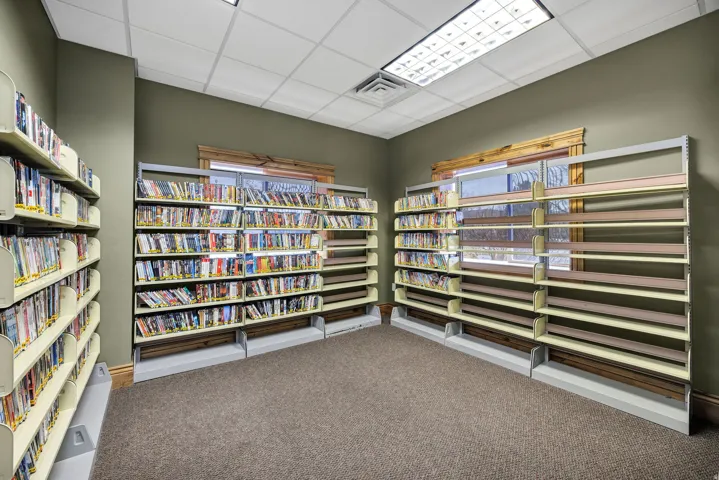Specialty room featuring integrated shelving units, carpeted flooring, and a drop ceiling with recessed lighting