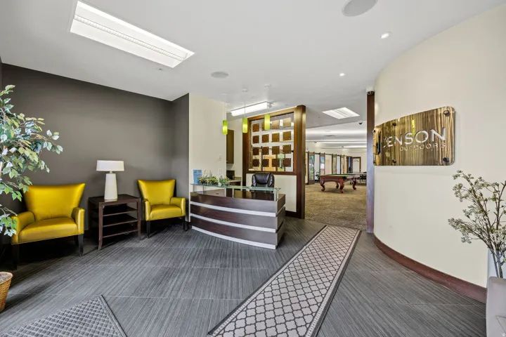 Lobby area featuring wood-finish flooring, a contemporary reception desk, recessed lighting, and a decorative rug runner