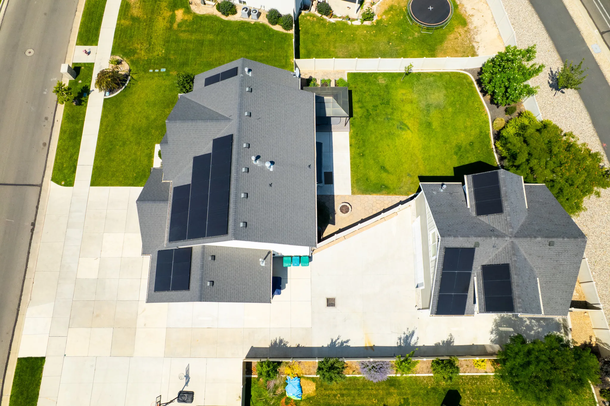 Multiple roof-mounted solar panel arrays on two distinct residential structures