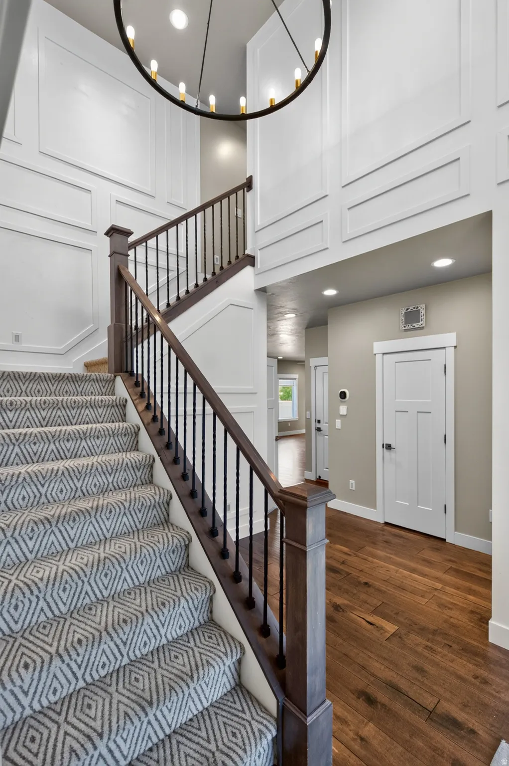 Grand entry featuring a two-story foyer with decorative wainscoting