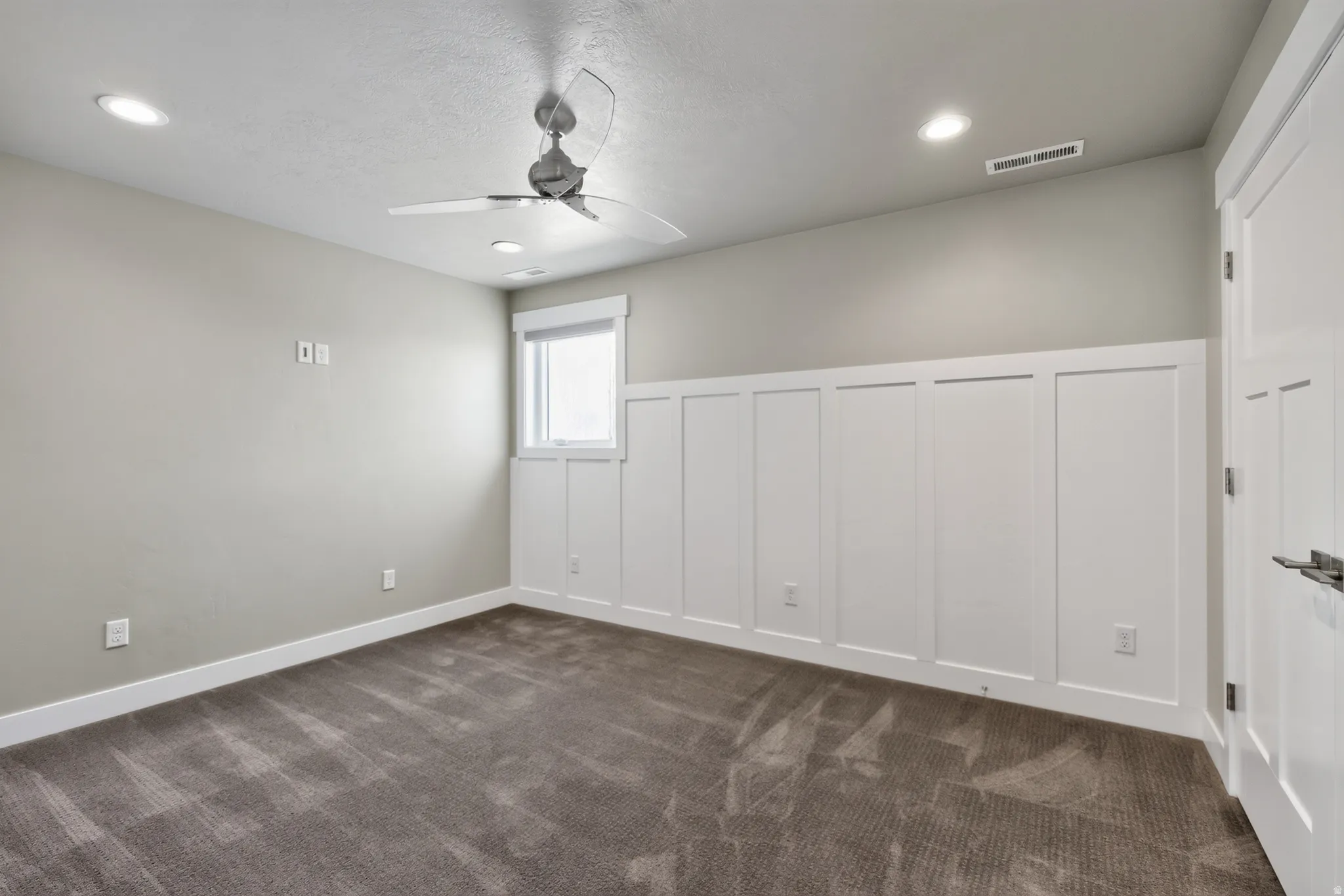 Room featuring a paneled accent wall, a window, recessed lighting, a ceiling fan, and carpeted flooring