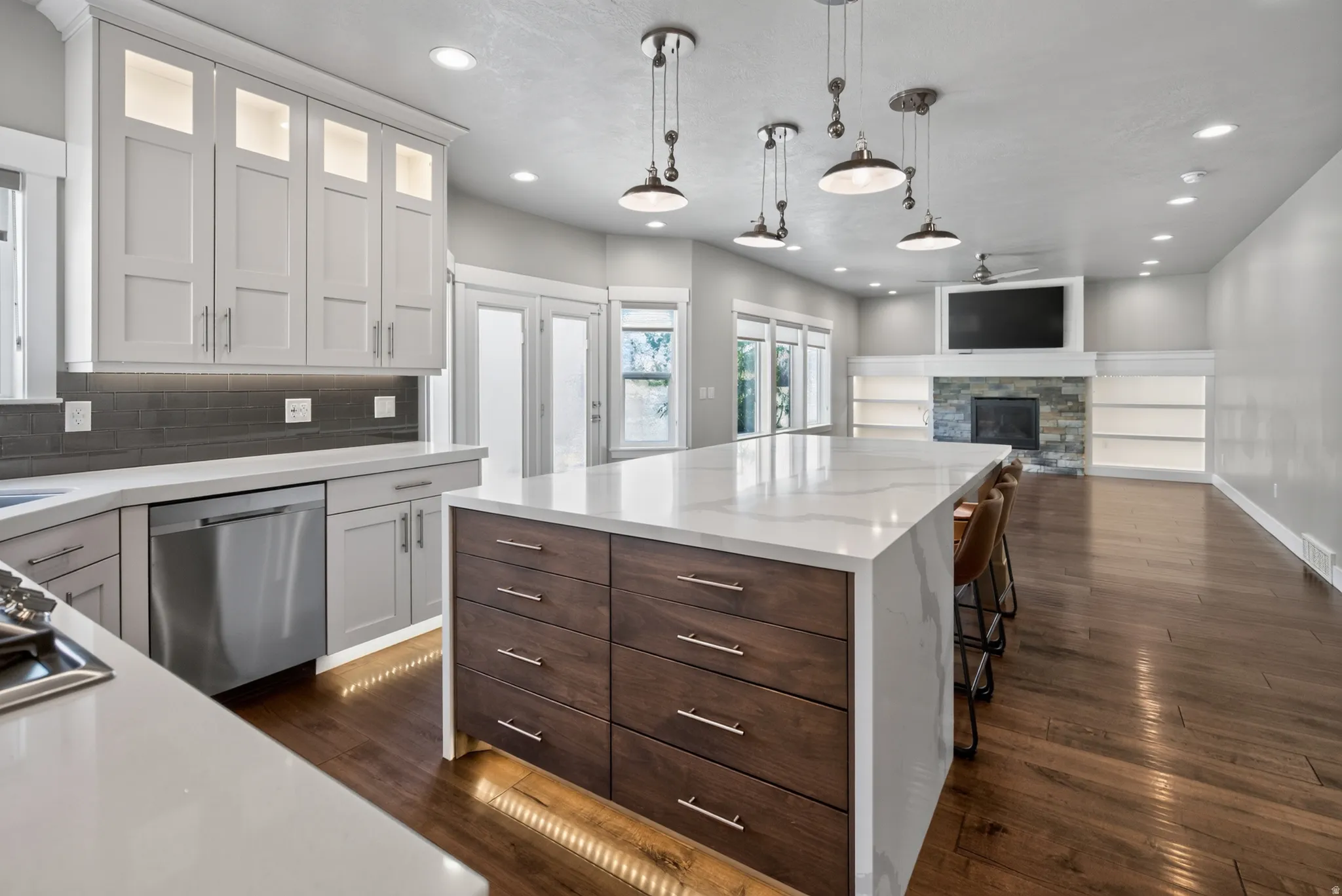 Gourmet kitchen featuring a large island with quartz countertops, stainless steel appliances, and integrated lighting