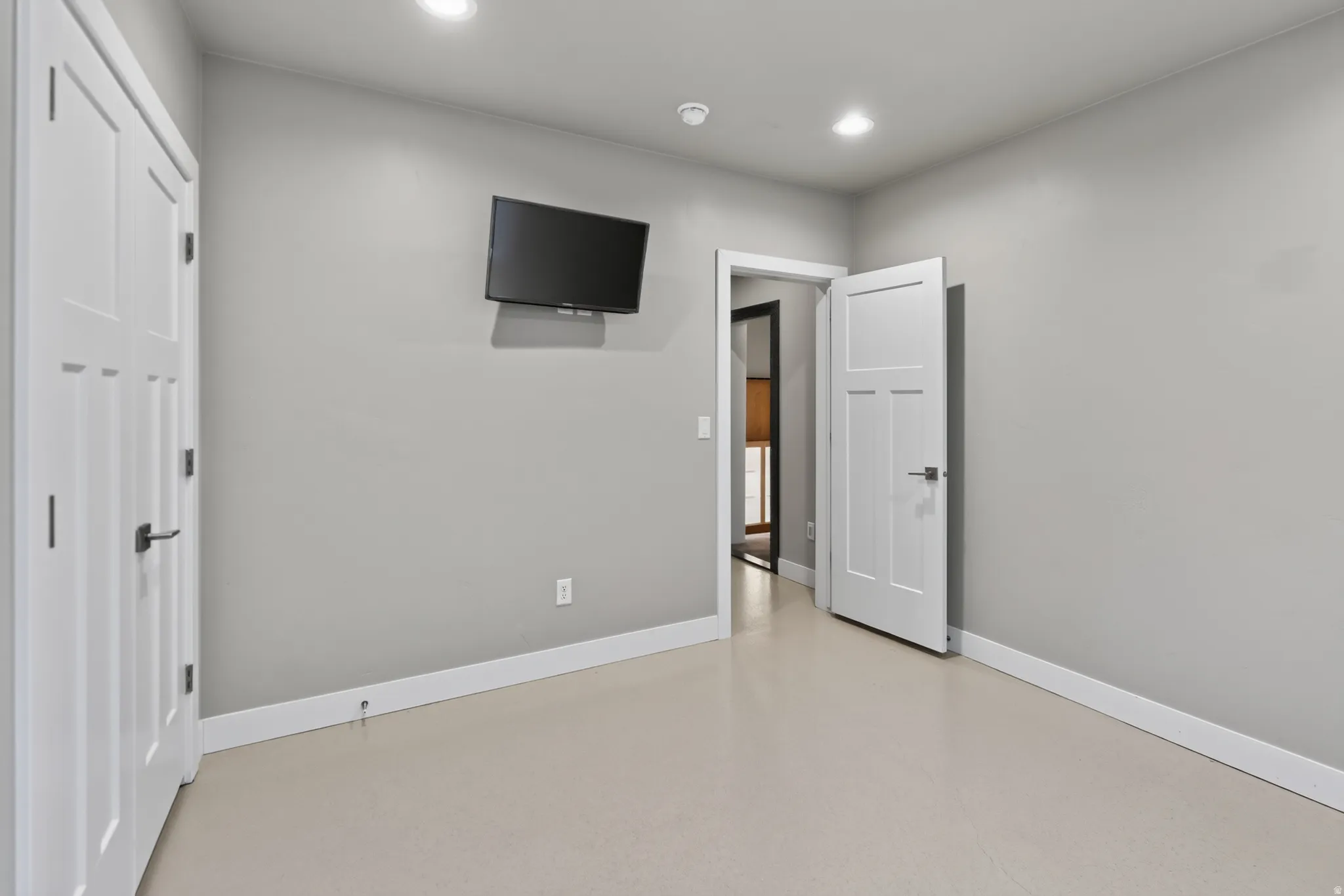 Spacious room featuring light-toned flooring and neutral wall tones