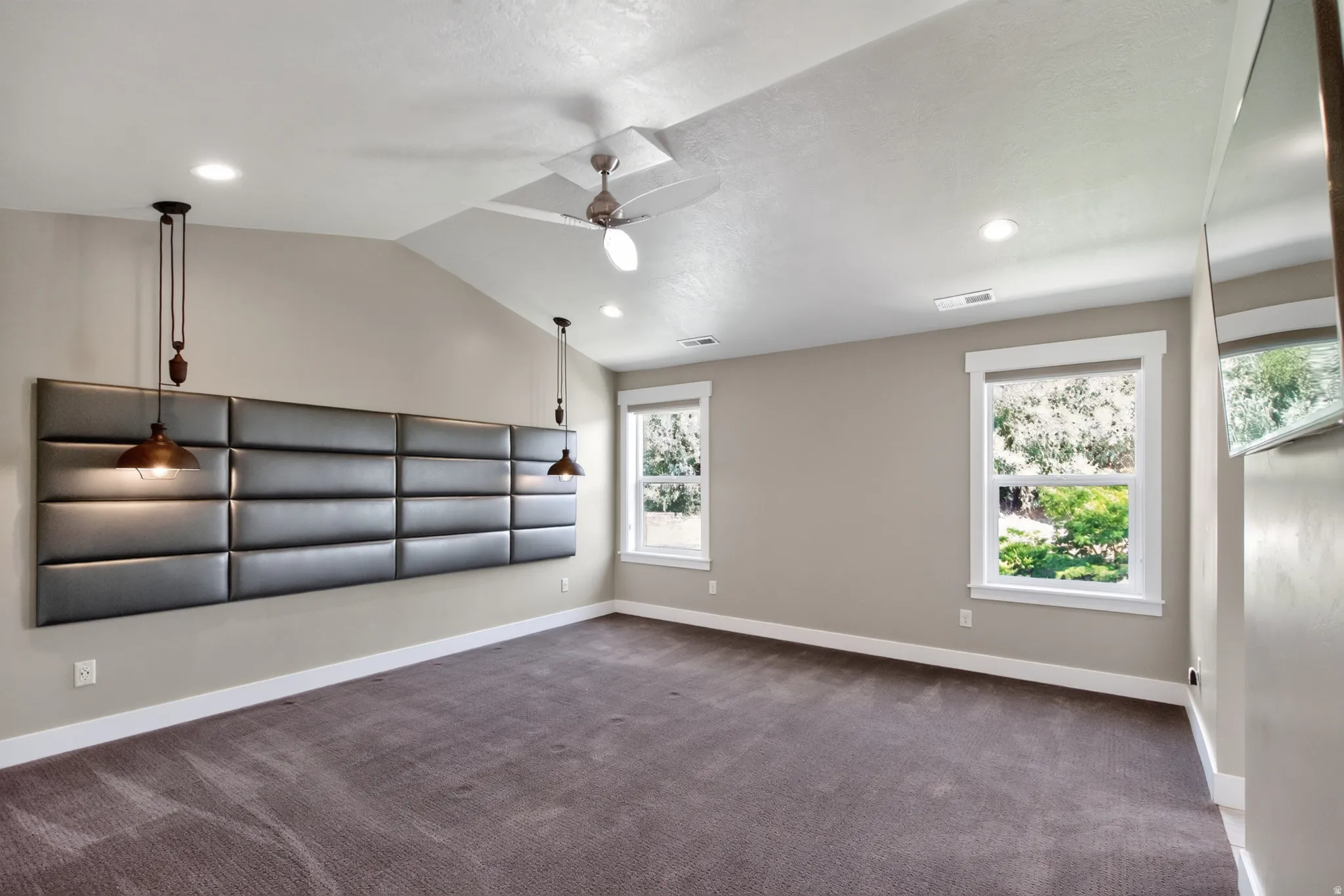Spacious room featuring vaulted ceilings, recessed lighting, and a contemporary ceiling fan