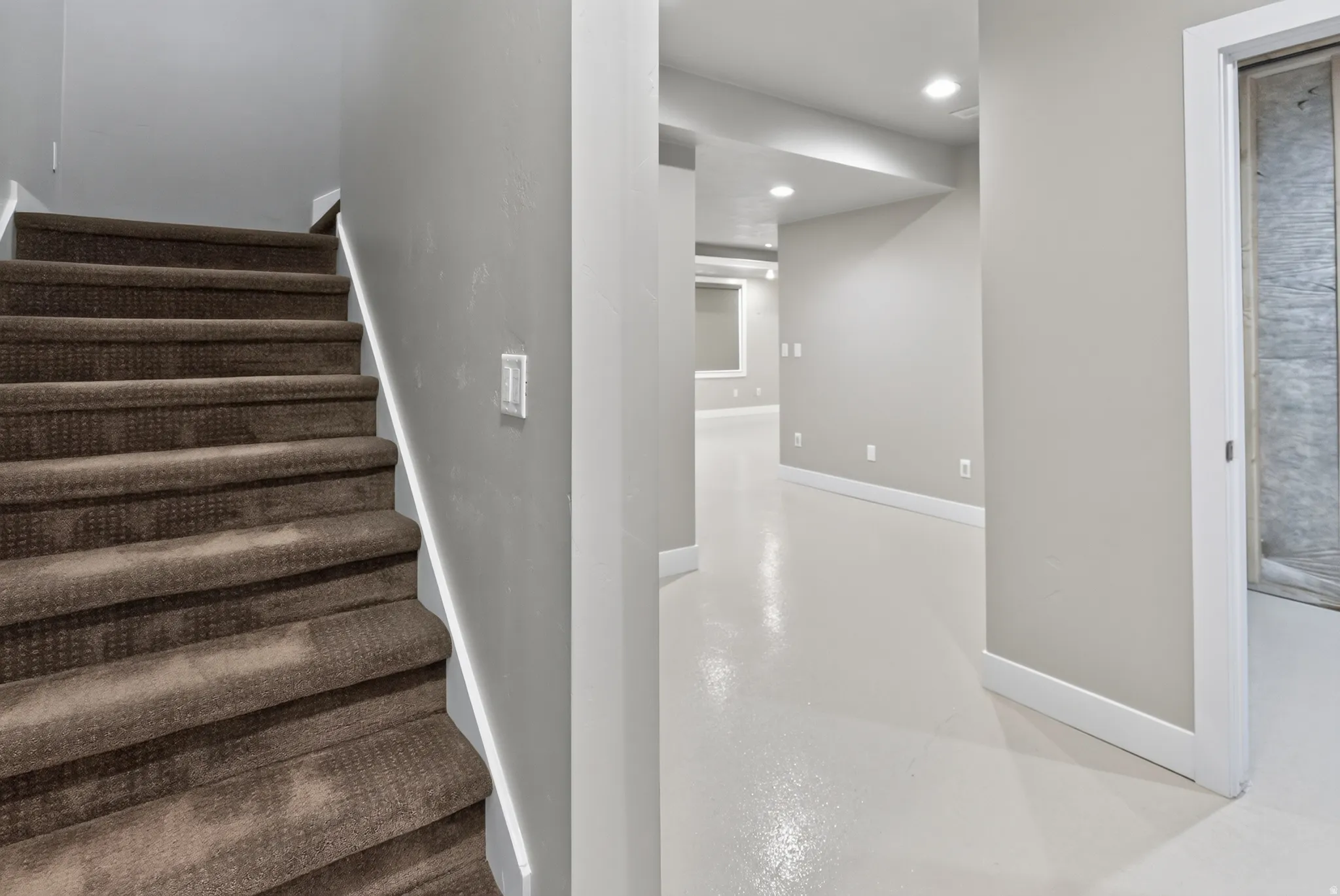 Carpeted staircase with light gray painted walls and white trim