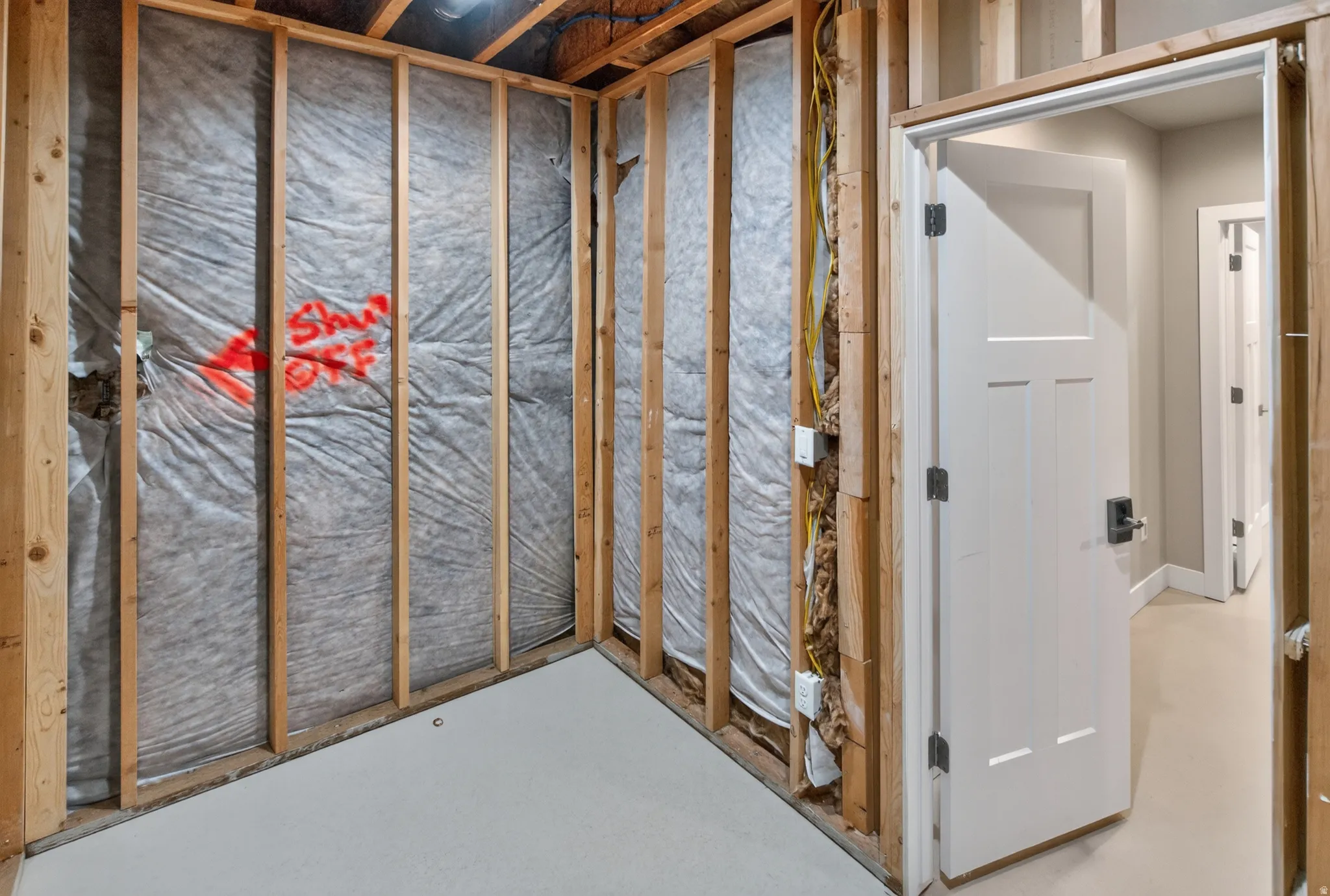 Unfinished interior space featuring exposed wood framing and insulation