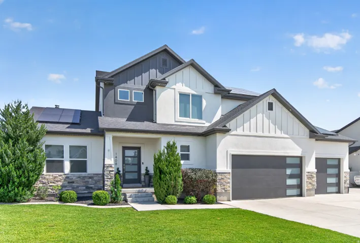 Contemporary facade featuring a dual-tone exterior, stone accents, and a covered entry