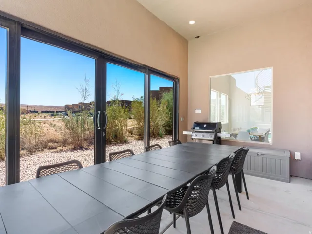 Outdoor patio with expansive sliding glass doors, a built-in outdoor grill, and high ceilings