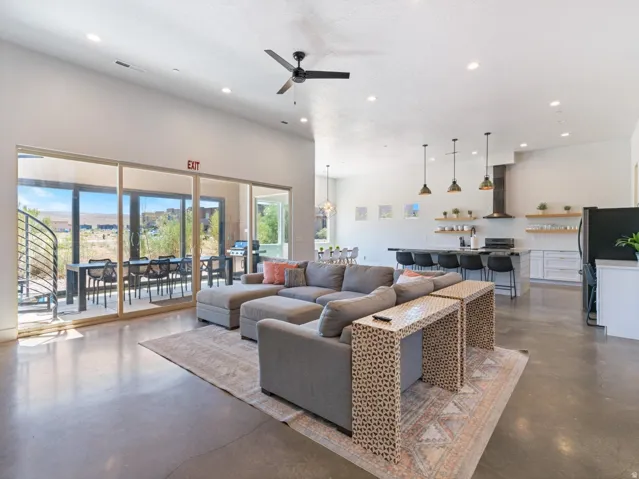 Expansive open-concept space featuring polished concrete flooring, recessed lighting, and a modern ceiling fan