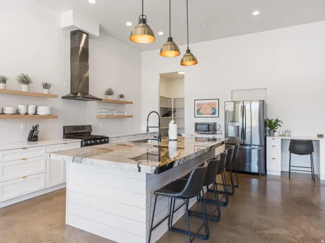 Spacious kitchen featuring an expansive island with stone countertops and integrated seating