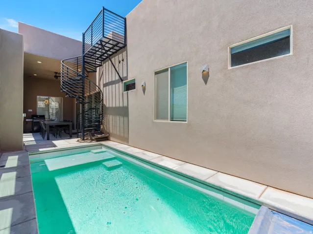 Outdoor plunge pool with integrated steps, surrounded by light-toned pavers