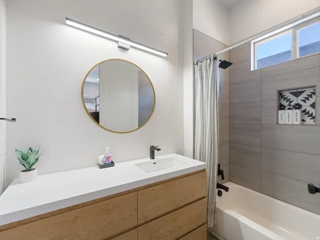 Contemporary bathroom featuring a light wood-finish vanity with a white countertop and undermount sink