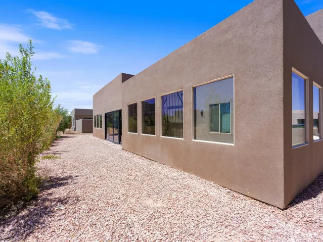 Contemporary stucco exterior with multiple large windows and a glass-paneled door