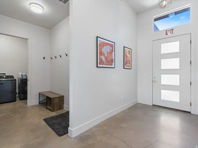 Entryway with polished concrete flooring and a modern door featuring four frosted glass panels
