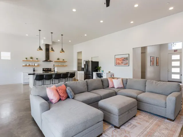 Open-concept living space featuring high ceilings, recessed lighting, and polished concrete flooring