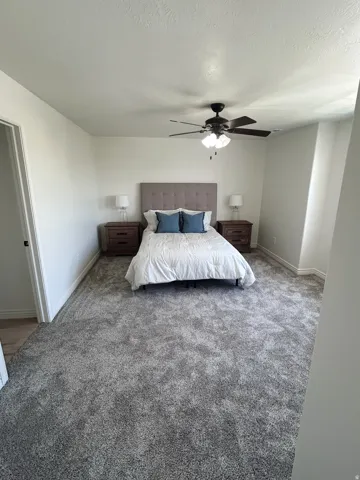 Neutral tone wall paint, wood-finish flooring, and a ceiling fan with integrated lighting