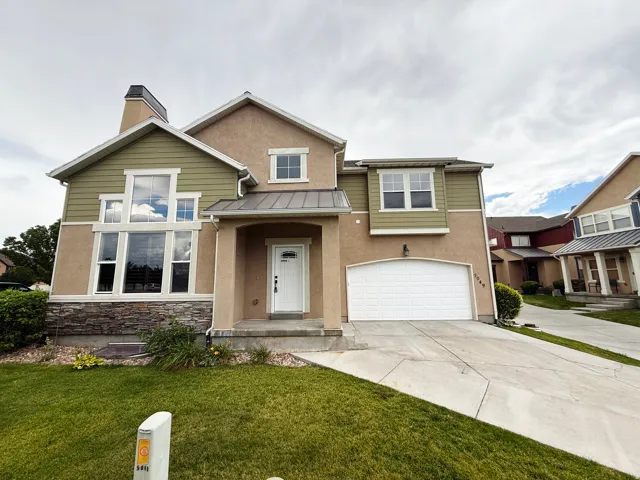 Two-story stucco and siding residence featuring a prominent stone accent facade