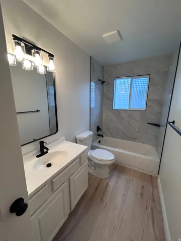 Bathroom featuring a modern vanity with white countertop, black fixtures, and a large mirror