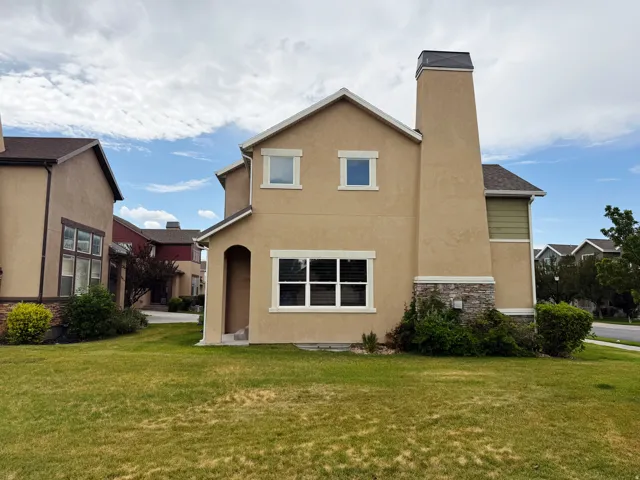 Stucco exterior featuring a prominent chimney with stone accents