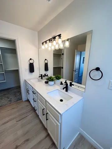 Dual vanity with white cabinetry, matte black hardware, and integrated sinks
