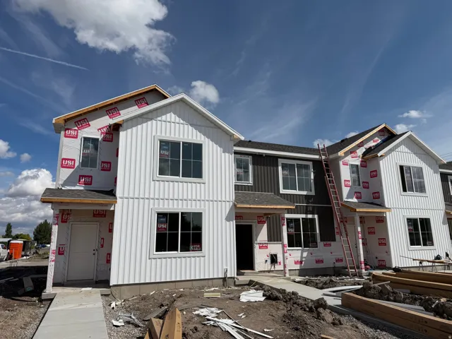 Modern townhouse facade with vertical white siding and dark gray horizontal siding accents