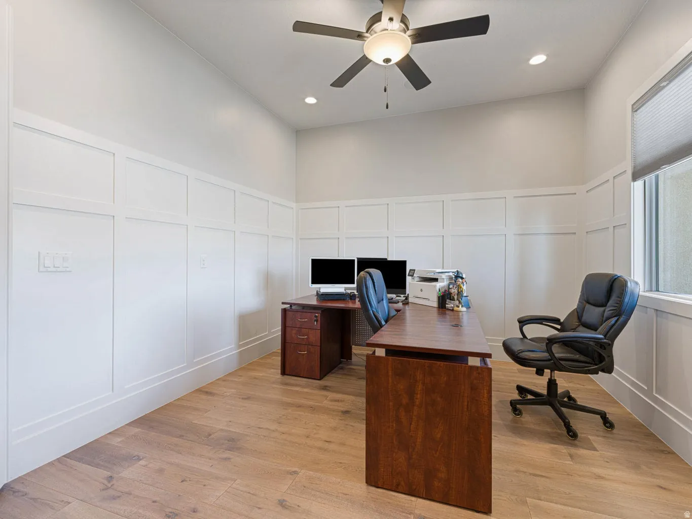 Room featuring wood-finish flooring, wainscoting, recessed lighting, and a ceiling fan