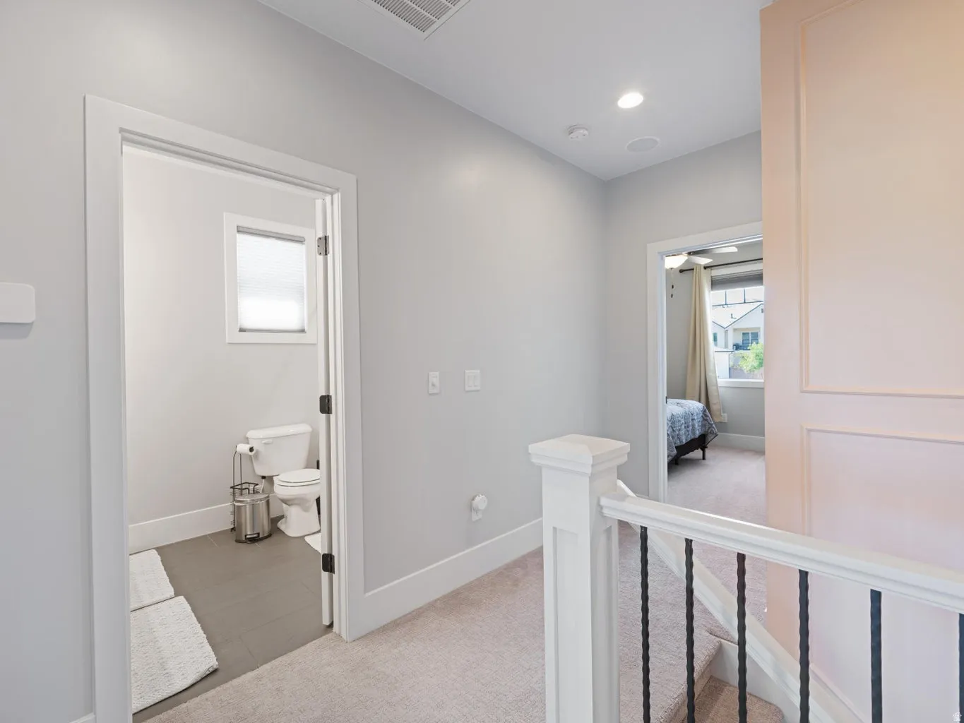 Upper-level hallway featuring a carpeted floor, light gray walls, and white trim