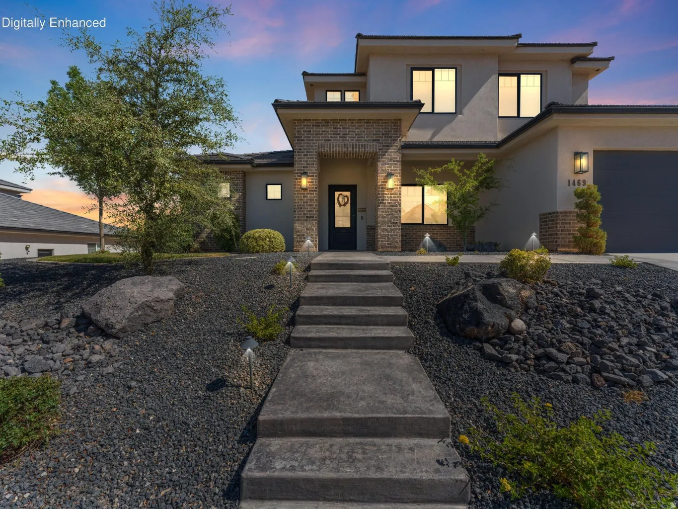 Modern façade featuring a stone-clad entry, stucco exterior, and multi-pane windows