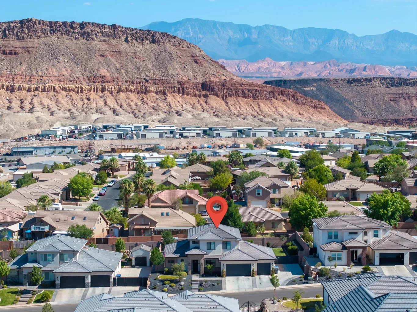 Suburban neighborhood featuring a variety of residential properties, mountainous terrain, and a clear sky