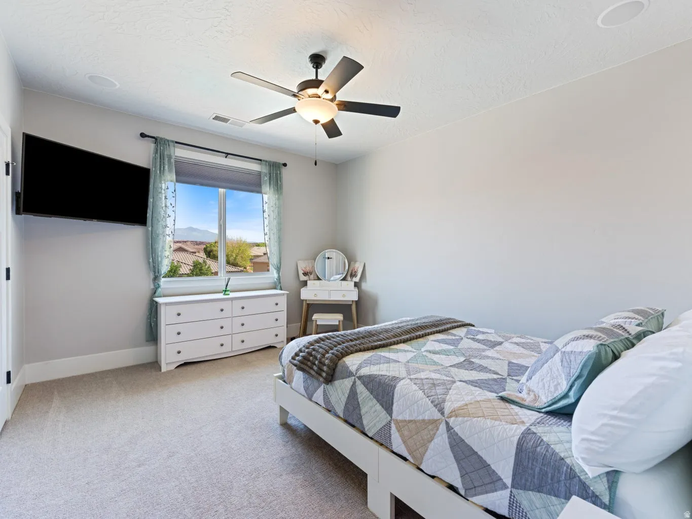Carpeted room with a large window offering mountain scenery