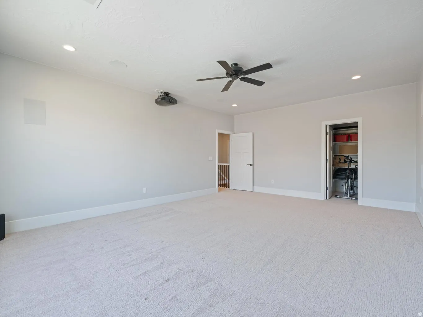 Spacious room featuring light-toned carpeting and light gray wall paint