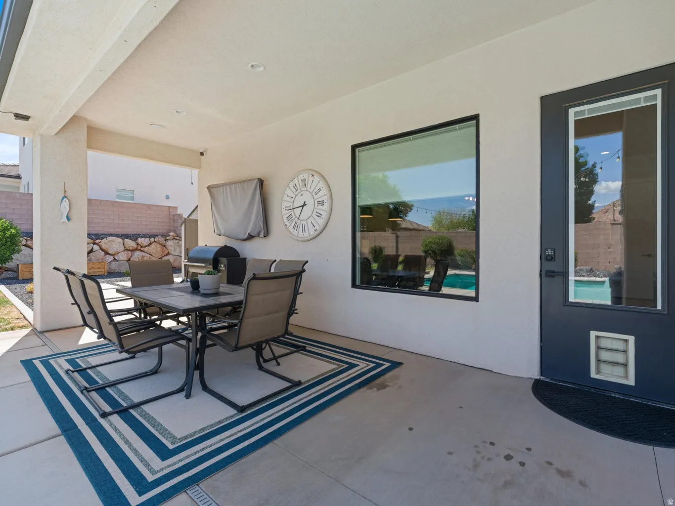 Covered patio with recessed lighting, large pane windows, and a glass-paneled exterior door