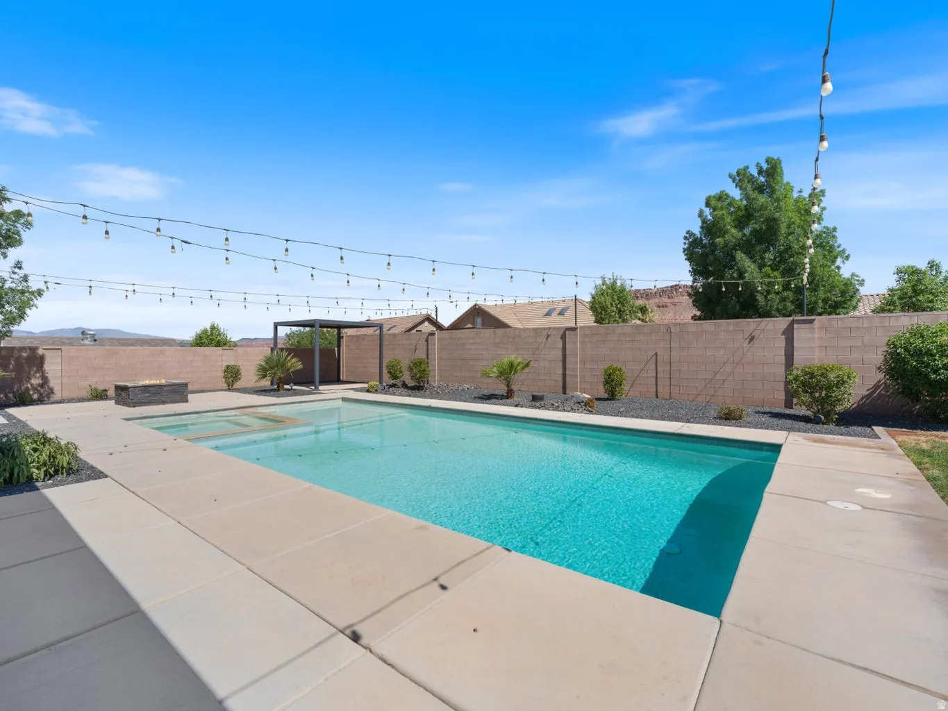 Rectangular swimming pool with integrated spa and concrete decking