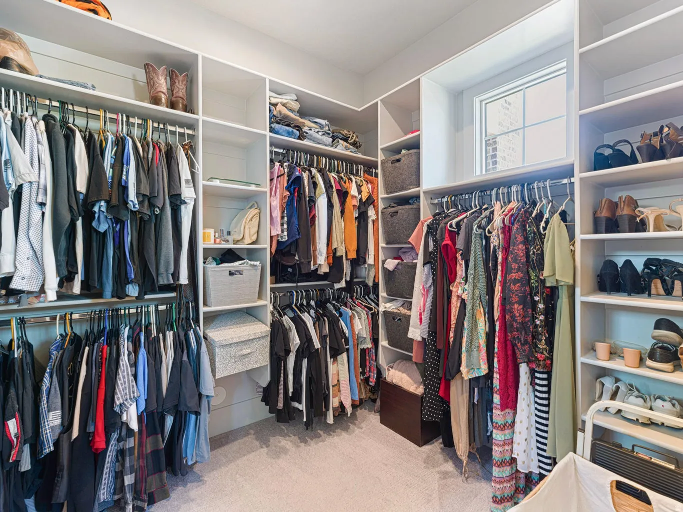 Custom closet system featuring extensive shelving and hanging rods