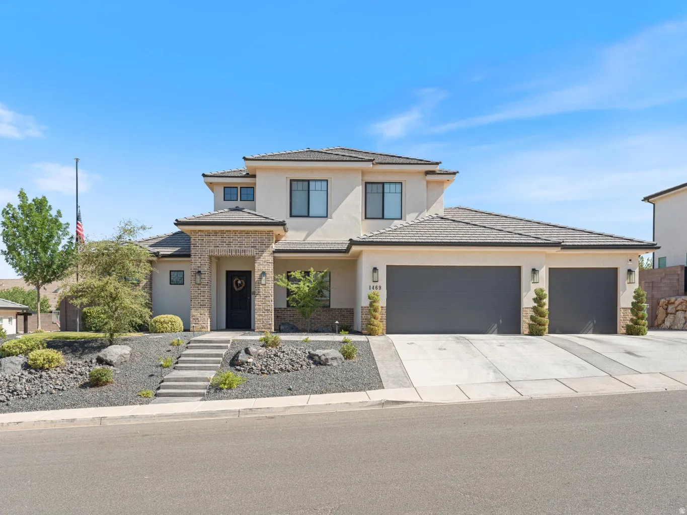 Contemporary stucco exterior with stone accents and a multi-level roofline